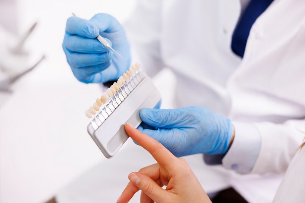 Detail of dentist showing zirconium dental facets color palette to patient