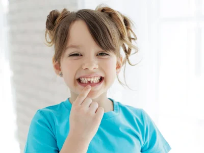 a young child showing her missing tooth