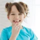 a young child showing her missing tooth