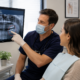 Dentist and patient reviewing radiographs while discussing a tooth extraction